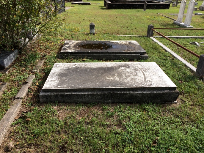 The topmost marker is that of Minnie's parents, Anne and John Kehoe. Minnie's is the bottom marker. The rain has disintegrated much of the engraving on these flat stones.